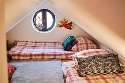 two futon beds in a attic with a mirror at Rusty's Cottage in Sedlčany