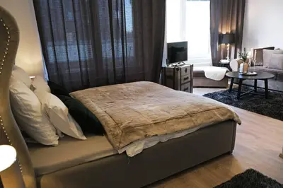 a bedroom with a bed and a living room at Sublime Studio with Big Terrace in Prague
