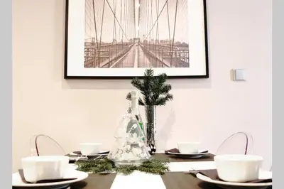 a dining room table with a picture of a bridge at Sublime Studio with Big Terrace in Prague