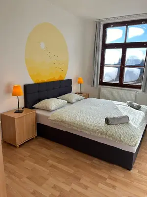 a bedroom with a bed and a large window at Penzion Maják in Dublovice