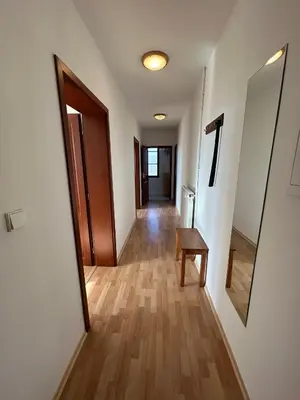 a hallway with a door and a table in a room at Penzion Maják in Dublovice