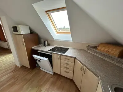 a small kitchen with a stove and a window at Penzion Maják in Dublovice