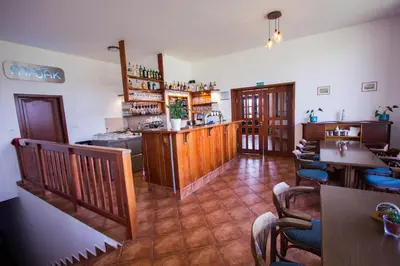 a restaurant with a bar and tables and chairs at Penzion Maják in Dublovice