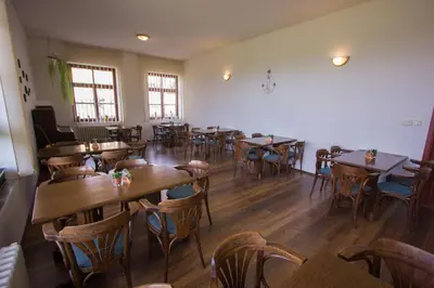 a restaurant with wooden tables and chairs in a room at Penzion Maják in Dublovice