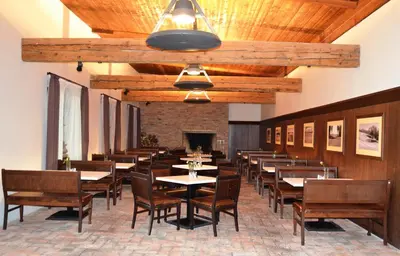 a dining room with tables and chairs and a fireplace at Sand Martin in Mladá Boleslav