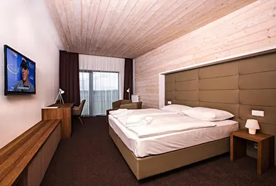 a hotel room with a large bed and a desk at Sand Martin in Mladá Boleslav