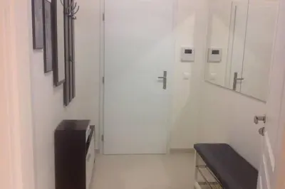 a white room with a door and a bench at Modern cozy apartment in central Prague in Prague