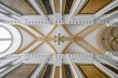 an ornate ceiling of a building with paintings on it at Modern cozy apartment in central Prague in Prague