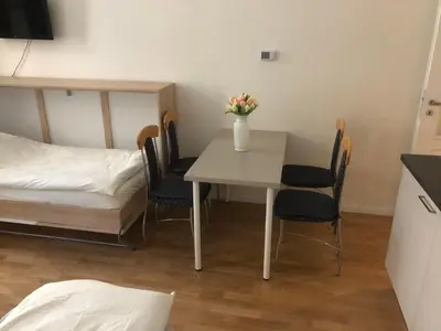 a small room with a table with chairs and a bed at Modern cozy apartment in central Prague in Prague