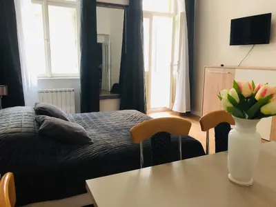 a bedroom with a bed and a table with a vase of flowers at Modern cozy apartment in central Prague in Prague