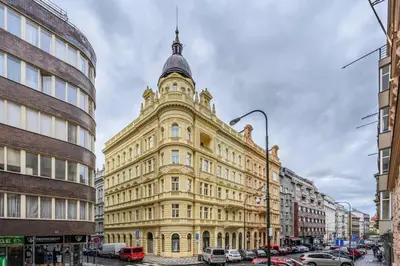 a large yellow building with a turret on a city street at Modern cozy apartment in central Prague in Prague