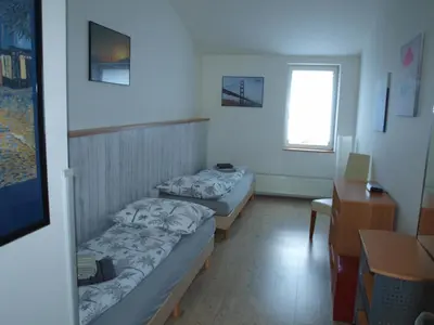 two beds in a small room with a desk and a desk at BAILANDO Studio in Neratovice