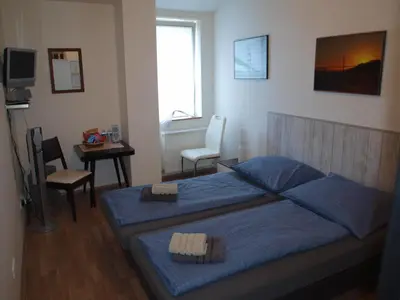 a bedroom with a blue bed and a table and chair at BAILANDO Studio in Neratovice