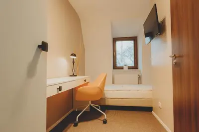 a bedroom with a bed and a desk and a chair at Penzion Nový Rybník in Obořiště