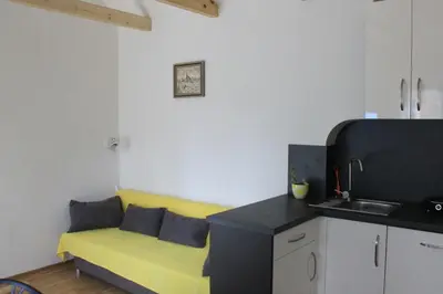 a living room with a yellow couch in a kitchen at Domek Praha - Zbraslav, u zámku in Prague