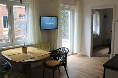 a living room with a table and a television on a wall at Domek Praha - Zbraslav, u zámku in Prague