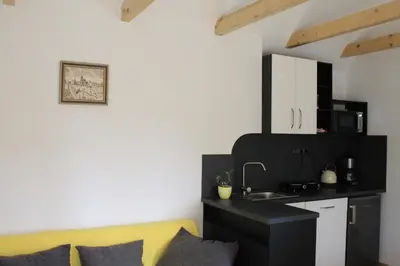 a living room with a yellow couch and a kitchen at Domek Praha - Zbraslav, u zámku in Prague