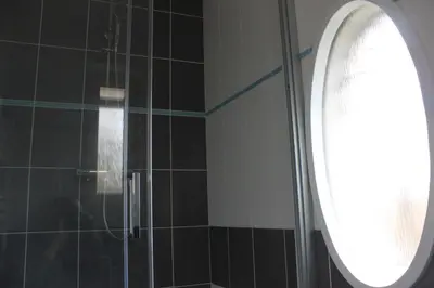 a shower with a glass door and a window at Domek Praha - Zbraslav, u zámku in Prague