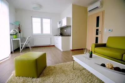 a living room with a green couch and a table at Black Bridge Hotel Apartment in Prague