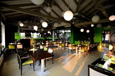 a restaurant with wooden tables and chairs and green walls at Black Bridge Hotel Apartment in Prague