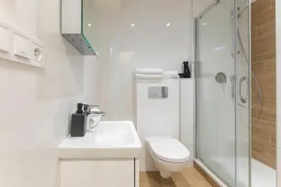 a white bathroom with a toilet and a shower at Lampi Aparthotel Prague in Prague