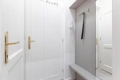a white bathroom with a shower and a glass door at Lampi Aparthotel Prague in Prague