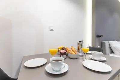 a table with cups and plates of food and drinks at Lampi Aparthotel Prague in Prague