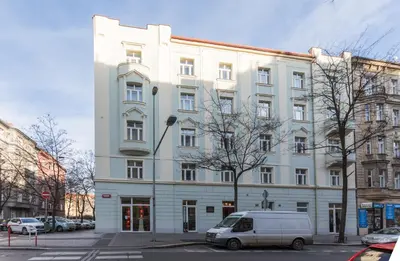 a white building with a van parked in front of it at Lampi Aparthotel Prague in Prague