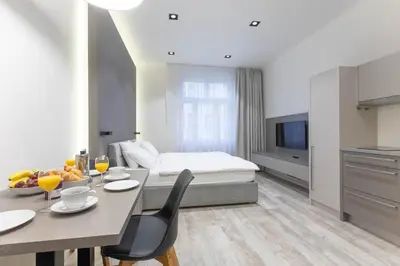 a hotel room with a bed and a table and chairs at Lampi Aparthotel Prague in Prague