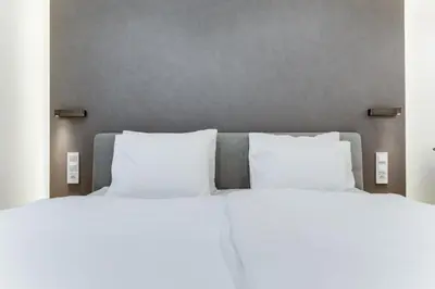 two beds with white pillows in a bedroom at Lampi Aparthotel Prague in Prague
