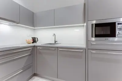 a kitchen with white cabinets and a microwave at Lampi Aparthotel Prague in Prague