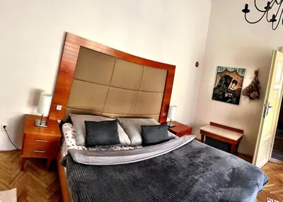 a bedroom with a large bed with a wooden headboard at Charming Old Town Retreat in Prague