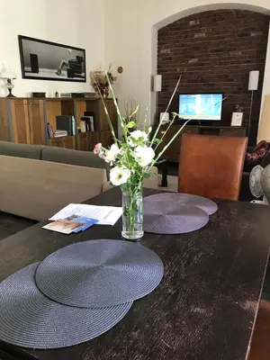 a table with two plates and a vase of flowers on it at Charming Old Town Retreat in Prague