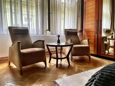 a living room with two chairs and a table and a couch at Charming Old Town Retreat in Prague