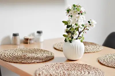 a table with a white vase with flowers in it at Apartmány Ve stodole in Roudnice nad Labem