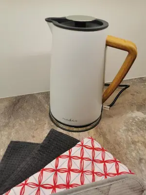 a coffee pot and a chair next to a table at Apartmány Ve stodole in Roudnice nad Labem