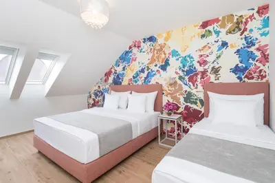 two beds in a room with a colorful wall at Eight Secrets Boutique Residence by Dwellfort in Prague