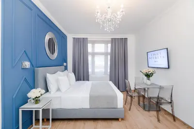 a blue and white bedroom with a bed and two tables at Eight Secrets Boutique Residence by Dwellfort in Prague