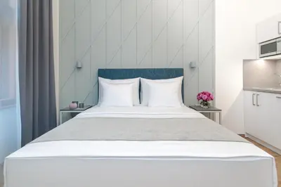 a bedroom with a large white bed with a blue headboard at Eight Secrets Boutique Residence by Dwellfort in Prague