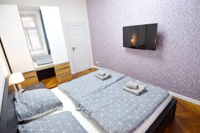 a bedroom with two beds and a flat screen tv at BRANDLY NEW APARTMENT ANDĚL in Prague