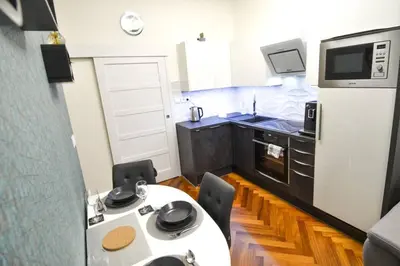 a small kitchen with a white table and a refrigerator at BRANDLY NEW APARTMENT ANDĚL in Prague