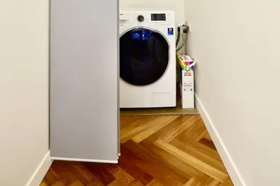 a washer and dryer in a room with a wooden floor at BRANDLY NEW APARTMENT ANDĚL in Prague