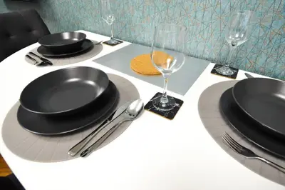 a white table with black plates and glasses and silverware at BRANDLY NEW APARTMENT ANDĚL in Prague