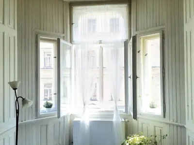 a room with two windows with white curtains and a radiator at VIP city CENTER apartment Prague in Prague