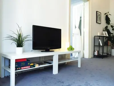a television on a white table in a living room at VIP city CENTER apartment Prague in Prague