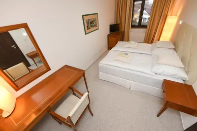 a small room with a bed and a mirror at Atrium-Accomm in Řitka