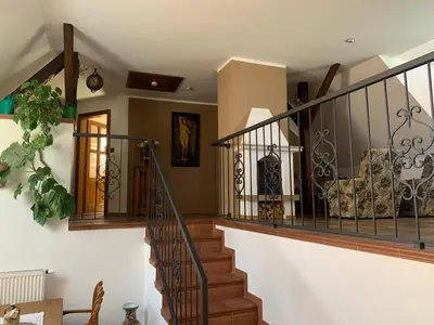 a staircase in a home with wooden stairs and white walls at Penzion Na Růžku in Sedlčany