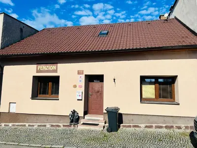 a building with a red roof and a brown door at Penzion Na Růžku in Sedlčany