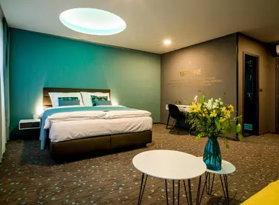 a hotel room with a bed and a vase of flowers at Rooftop Planet Prague Hotel in Prague