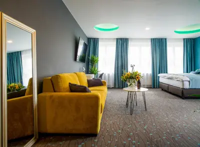 a living room with a yellow couch and a mirror at Rooftop Planet Prague Hotel in Prague